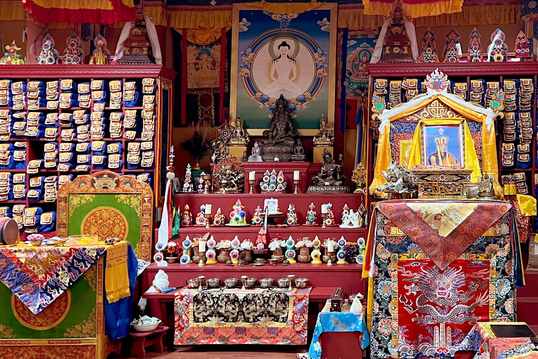 A shrine room densely filled with figures, painted hangings and offerings